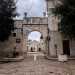 Per accedere alla corte in cui si trova il santuario oltrepassiamo un arco in pietra decorato da un bassorilievo della Vergine